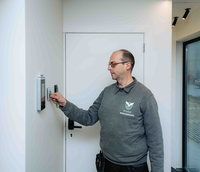 Kristof Devalckenaere demonstreert een modern toegangscontrolesysteem met badgelezer en NFC-technologie in een kantooromgeving, vakkundig geïnstalleerd voor veilige en efficiënte toegang.