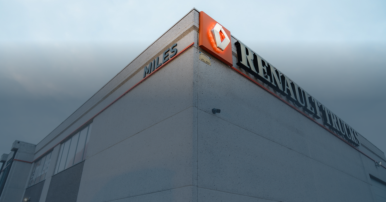 Een zwarte Ajax TurretCam beveiligingscamera gemonteerd op de grijze gevel van het Renault Trucks Miles gebouw voor professionele bedrijfsbeveiliging, geïnstalleerd door Kristof Devalckenaere.